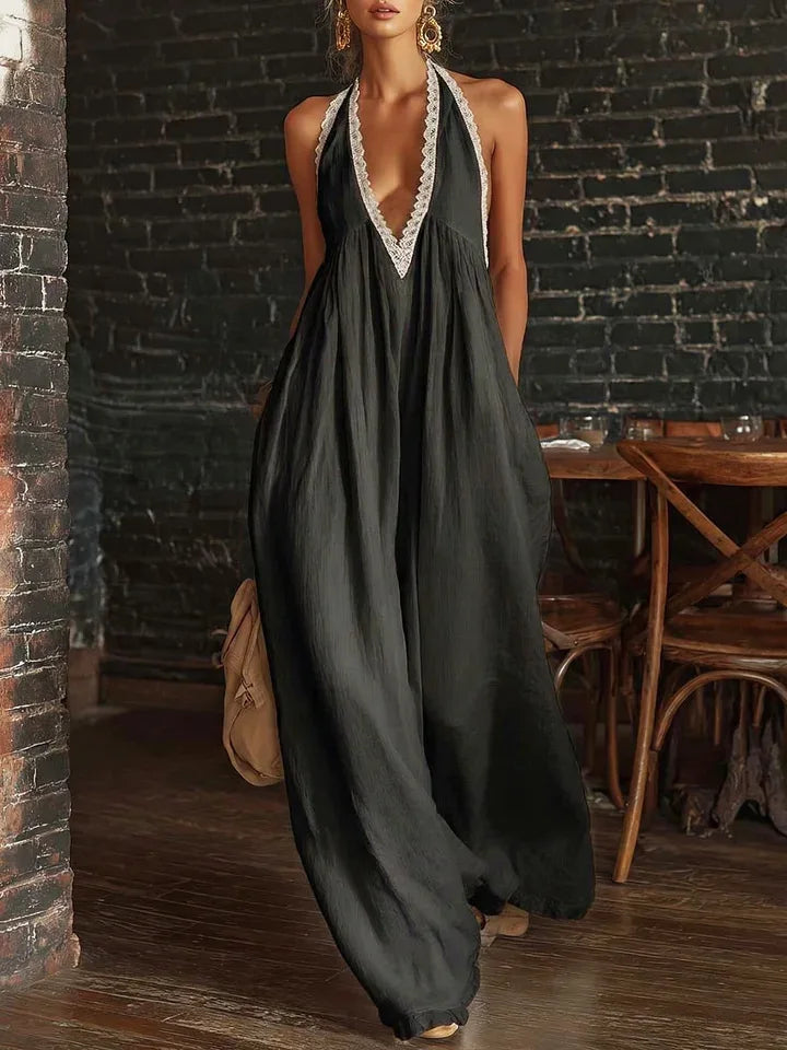 Woman wearing a long dark green dress with lace details in an indoor setting.