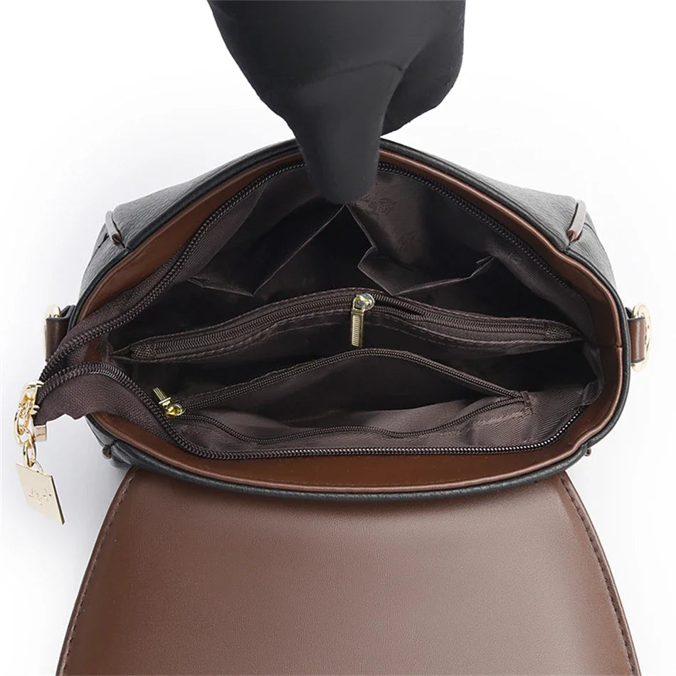 Brown leather handbag with open top showing interior on a white background