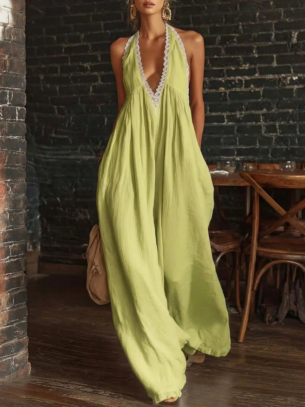 Woman wearing a light green halter neck dress in an indoor setting with wooden furniture.
