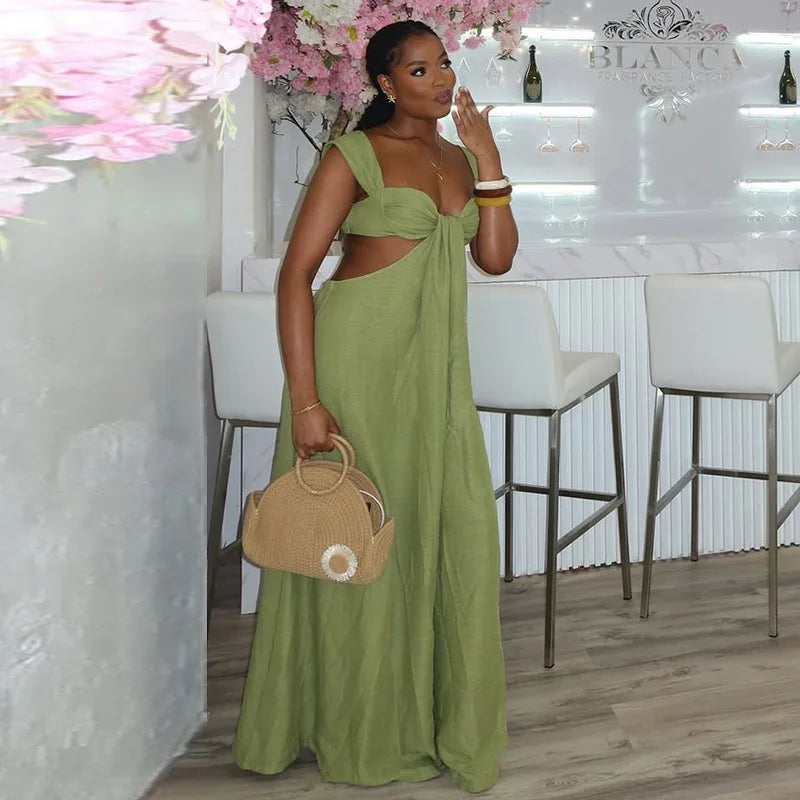 Woman in a green dress holding a beige handbag in a stylish interior setting.