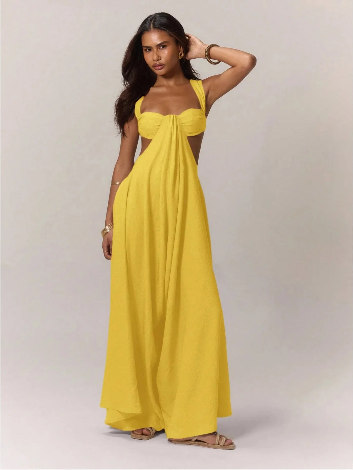 Woman wearing a yellow strapless dress against a plain background