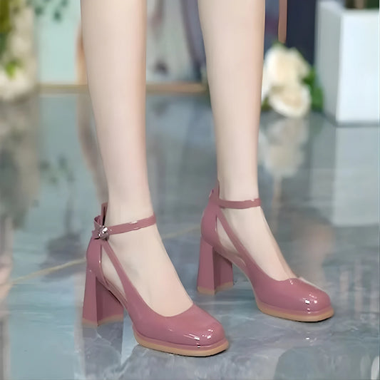 Purple high-heeled shoes worn by a person on a reflective floor.