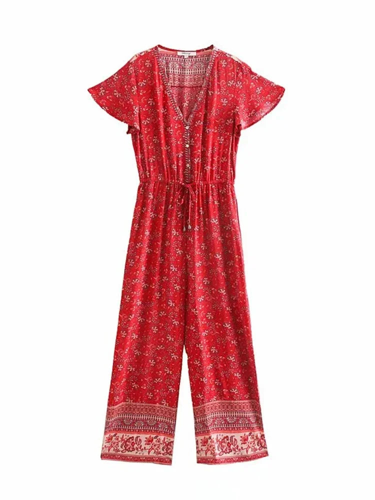 A red short-sleeve jumpsuit with a white floral print, a V-neckline, and a drawstring waist, shown against a plain white background.