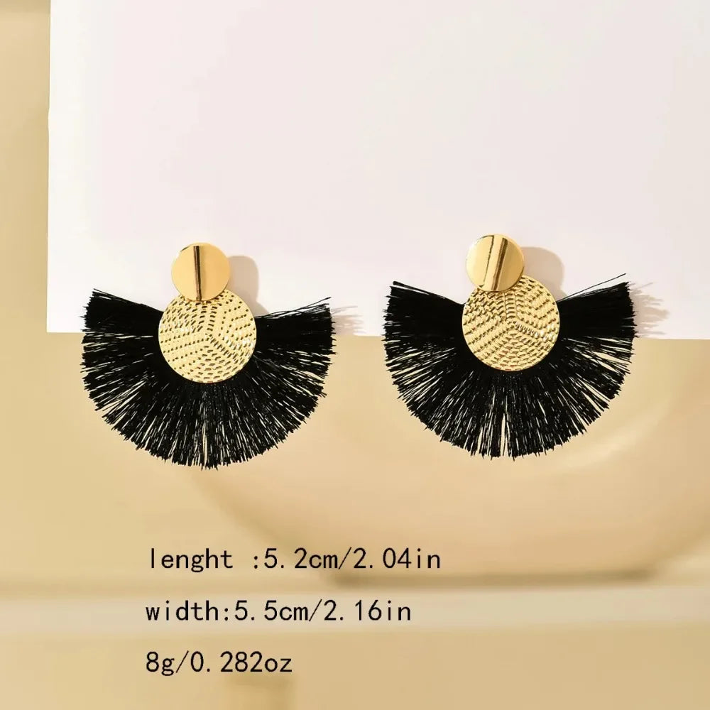 Black and gold earrings on a beige background with measurements.