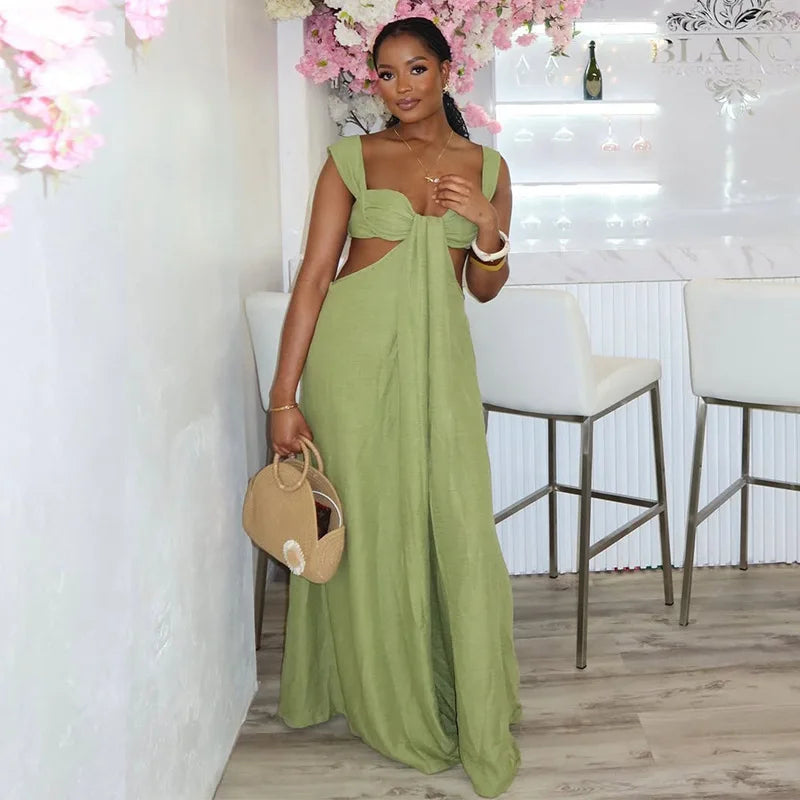 Woman in a green dress holding a beige handbag in a stylish interior setting.
