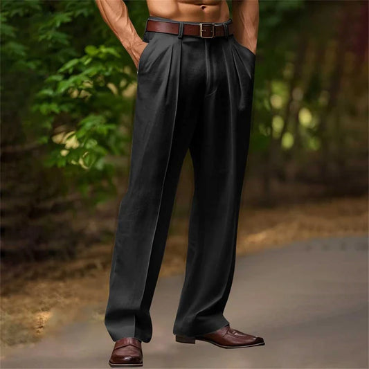 Person wearing black pants and brown shoes with a blurred natural background