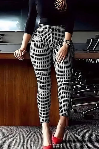 Person wearing black and white checkered pants with red shoes in an office setting