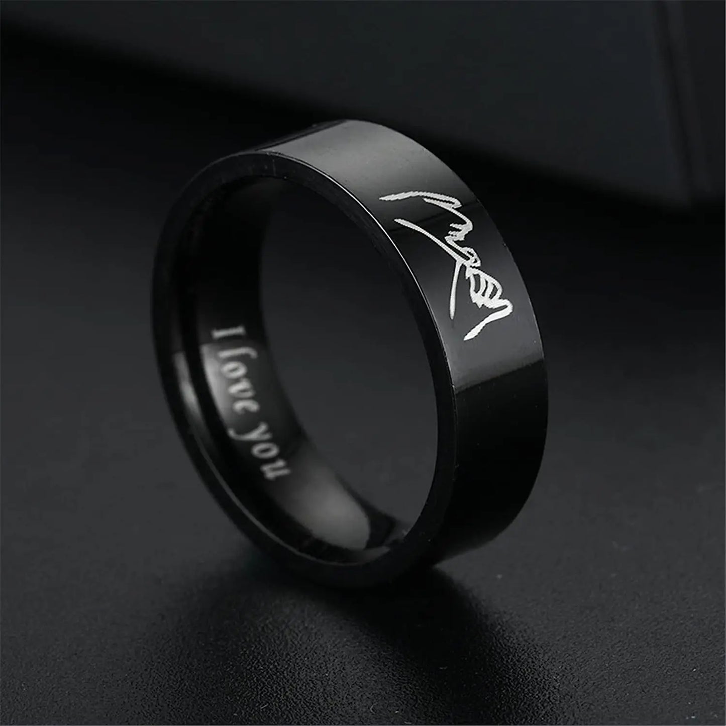 Black ring with 'I love you' engraving on a dark background