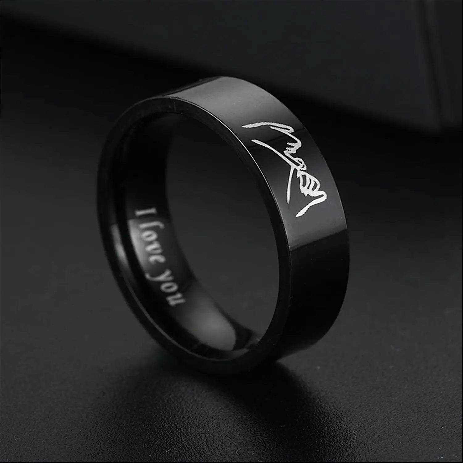 Black ring with 'I love you' engraving on a dark background