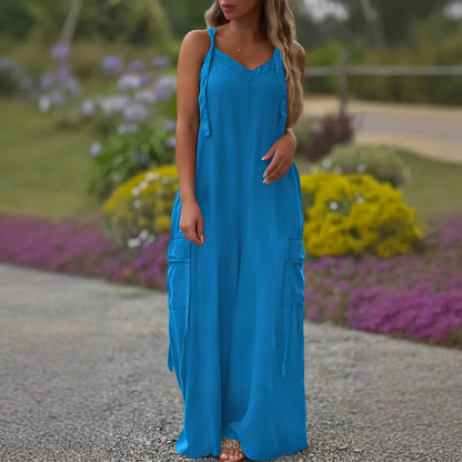 Woman wearing a blue dress standing outdoors with flowers in the background