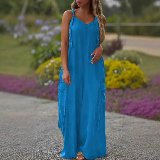 Woman wearing a blue dress standing outdoors with flowers in the background