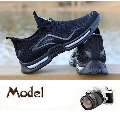 Black and gray athletic shoes with a camera on a wooden surface