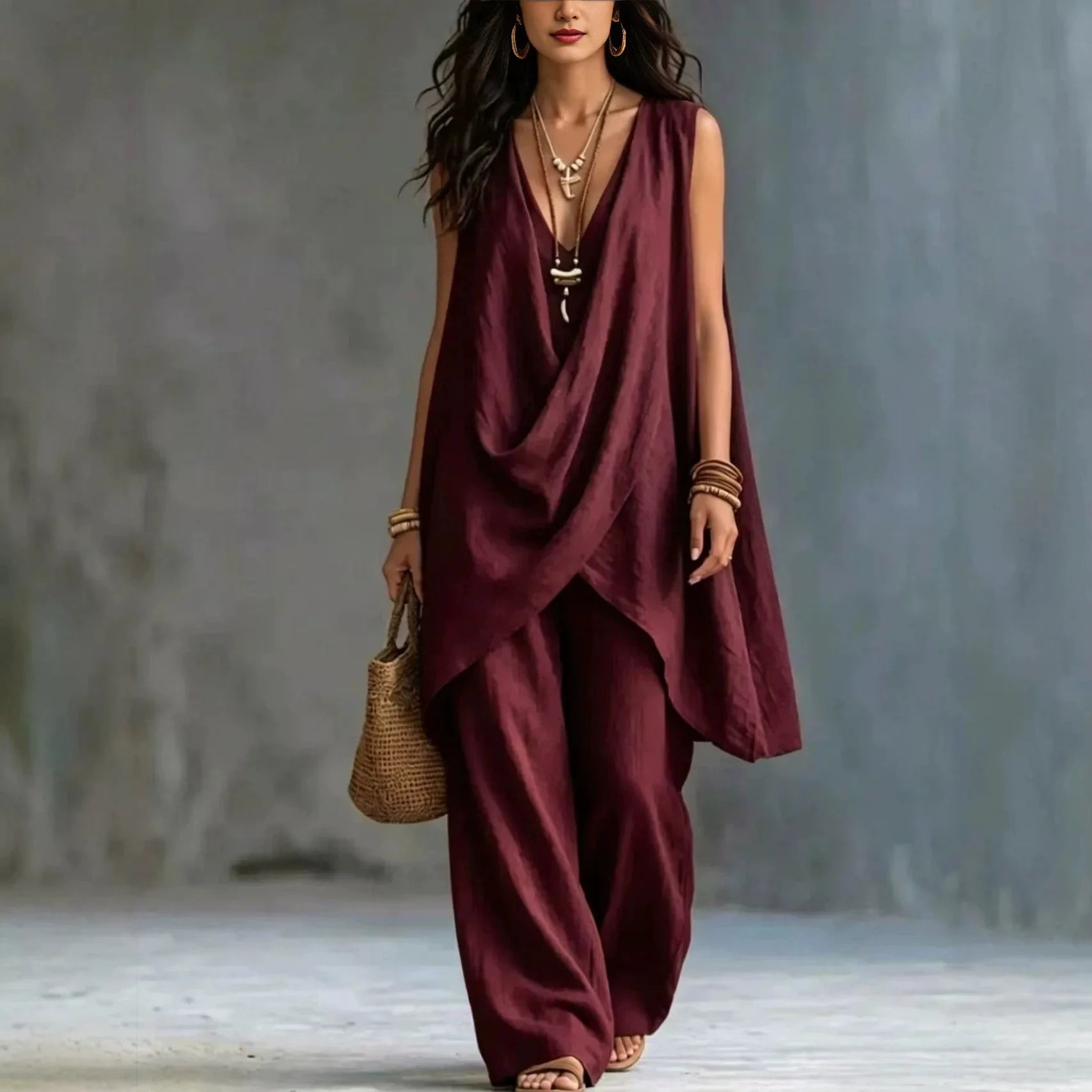 Woman wearing a burgundy sleeveless top and pants with a textured background