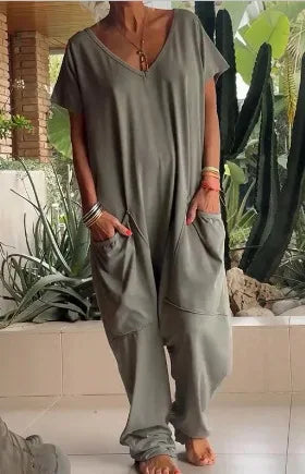Person wearing a loose-fitting olive green outfit with wide-leg pants in an outdoor setting.