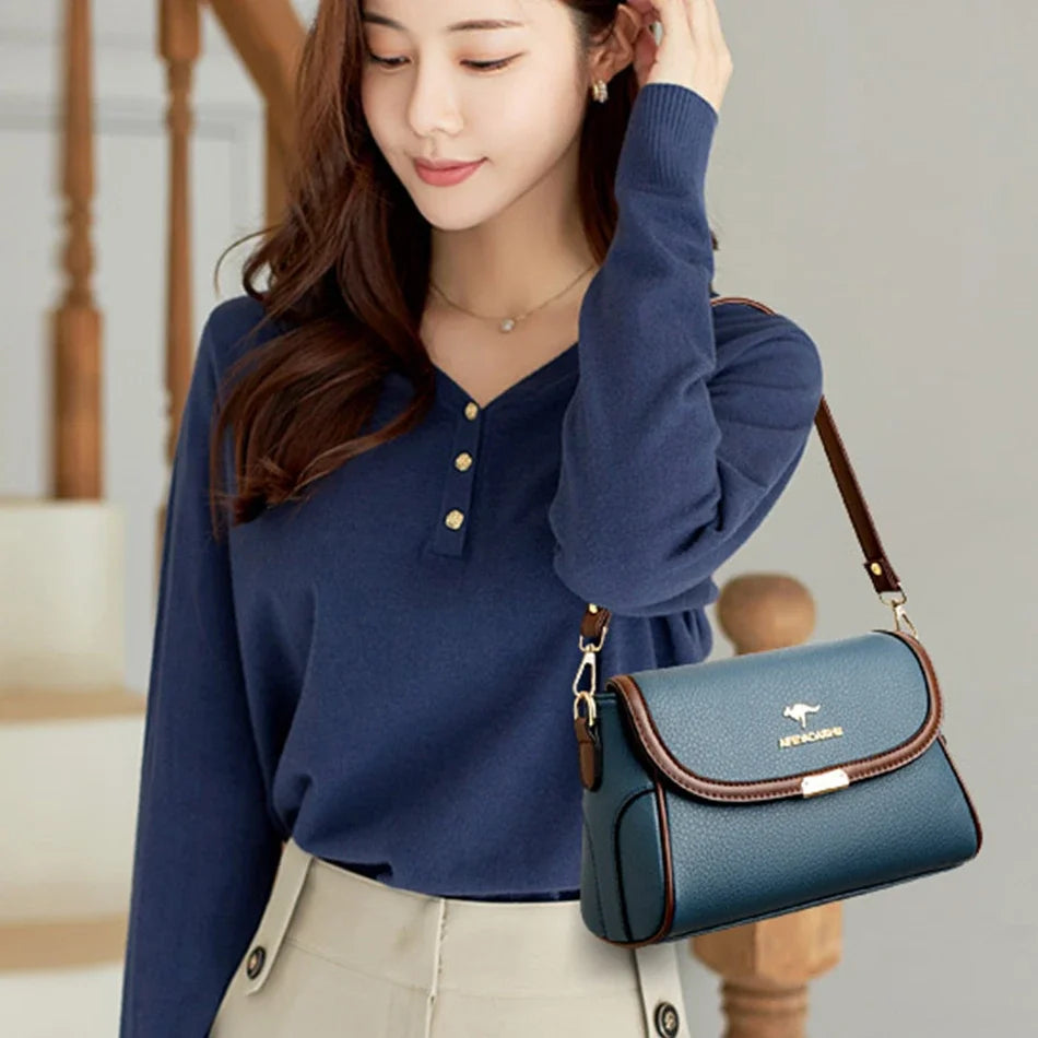 Woman holding a blue handbag with a visible brand logo, wearing a blue shirt.