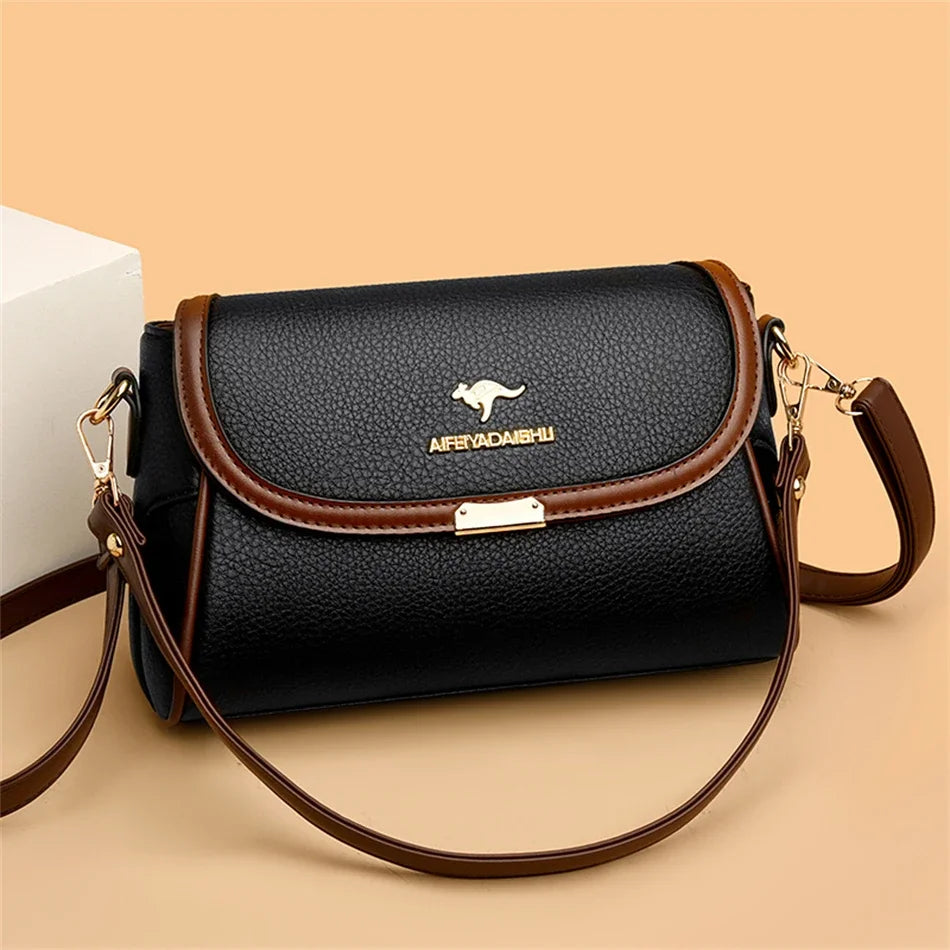 Black handbag with brown accents and a visible brand logo on a beige background