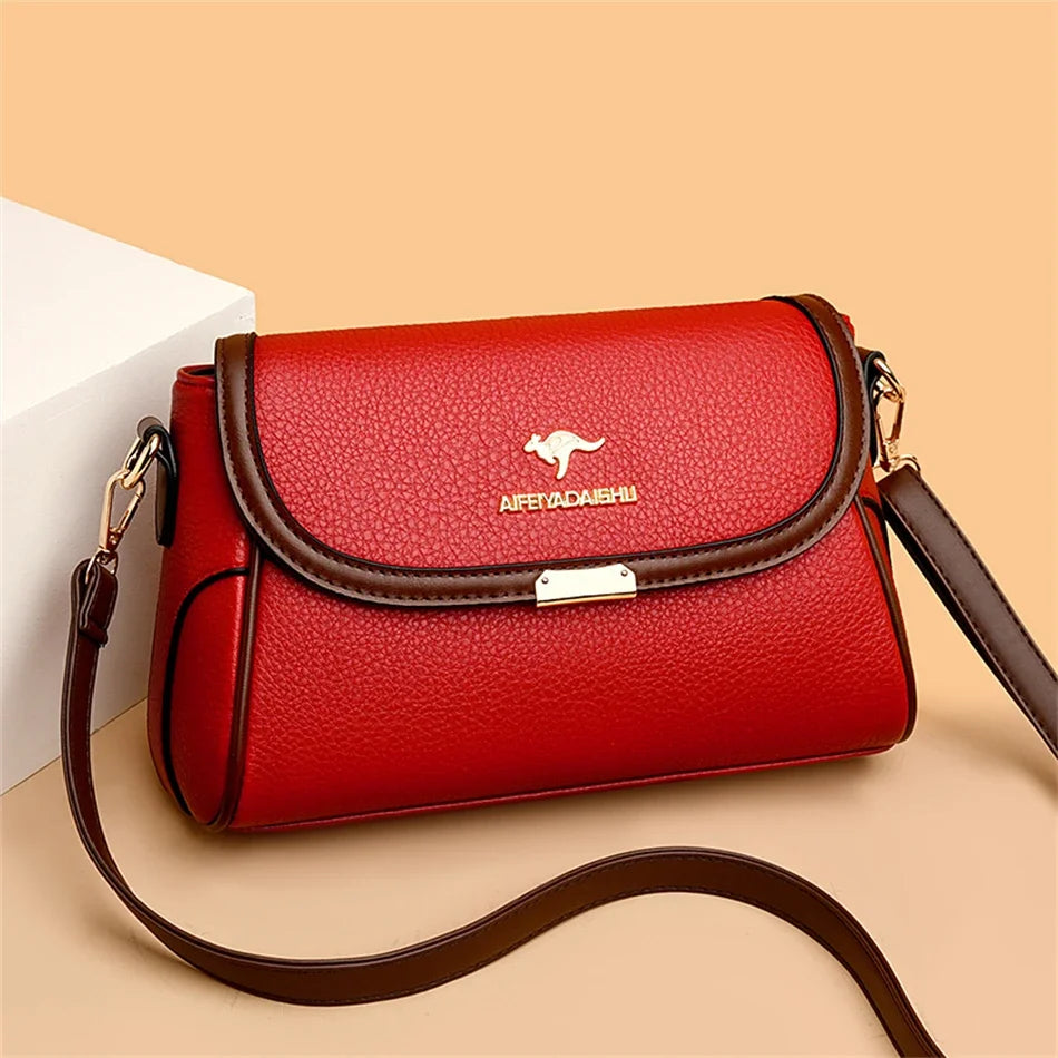 Red handbag with brown strap on a beige background