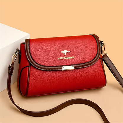 Red handbag with brown strap on a beige background