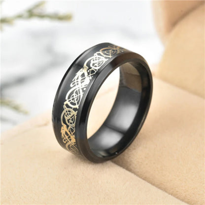 Black ring with gold Celtic knot design on a neutral background
