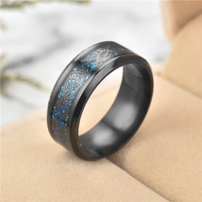 Black ring with blue glittery interior on a beige surface
