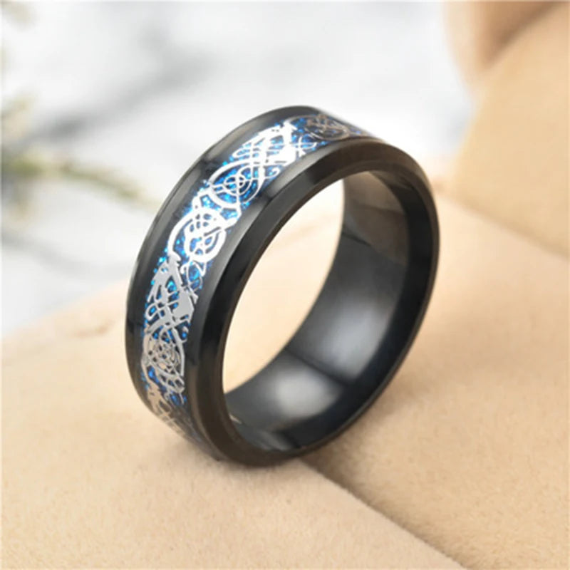 Black ring with blue and silver intricate design on a blurred background