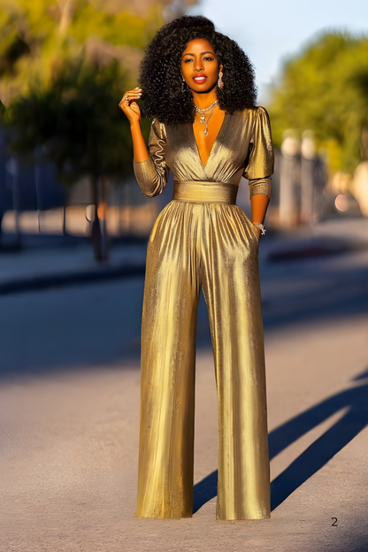 A person posing in the street in a flowing gold jumpsuit with wide legs and soft sunlight highlighting the fabric.