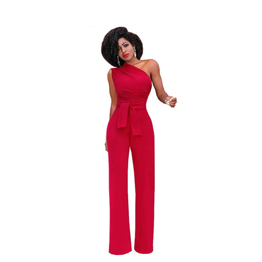 A woman modeling an elegant one-shoulder belted jumpsuit in black color with accessories.