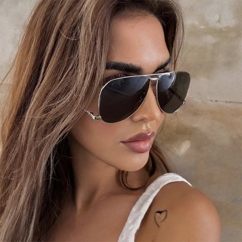 Woman wearing black sunglasses with a neutral background