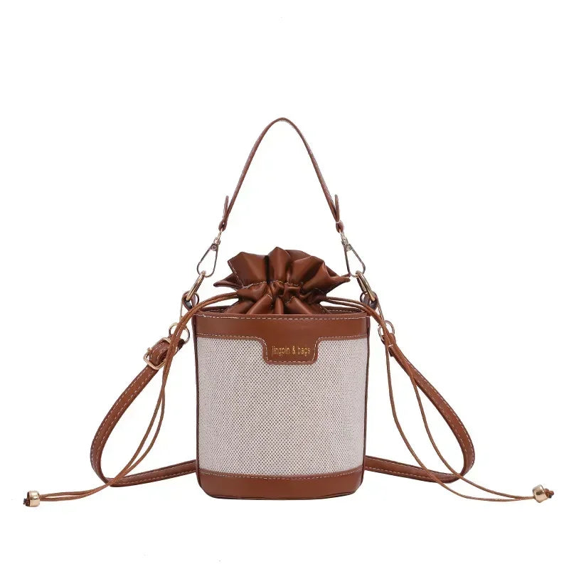 Brown and beige handbag with a bow on a white background