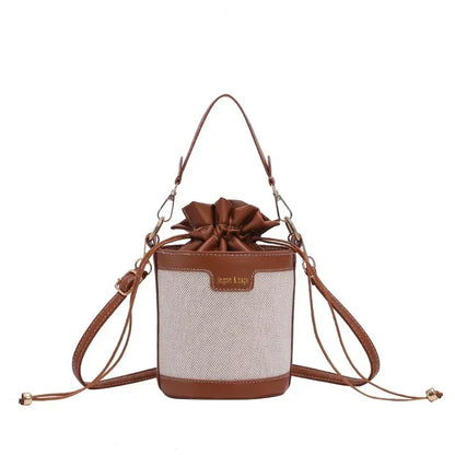 Brown and beige handbag with a bow on a white background