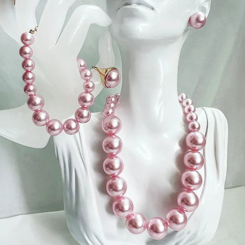 Pink pearl necklace and earrings on a mannequin bust.