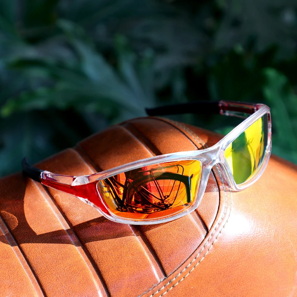 Sunglasses with reflective lenses on a brown leather surface with a blurred green background