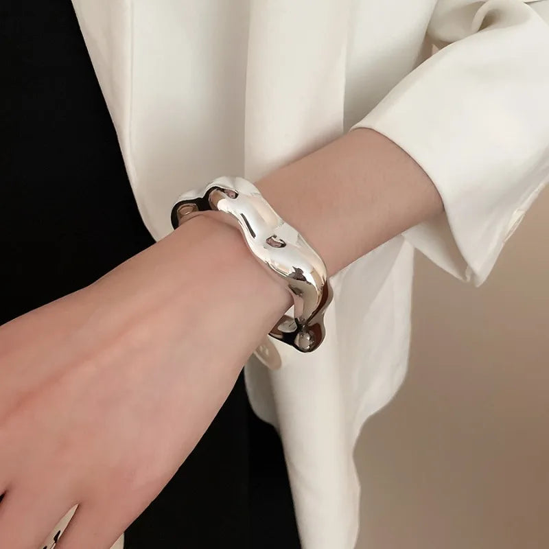 Silver bracelet on a wrist with a blurred background