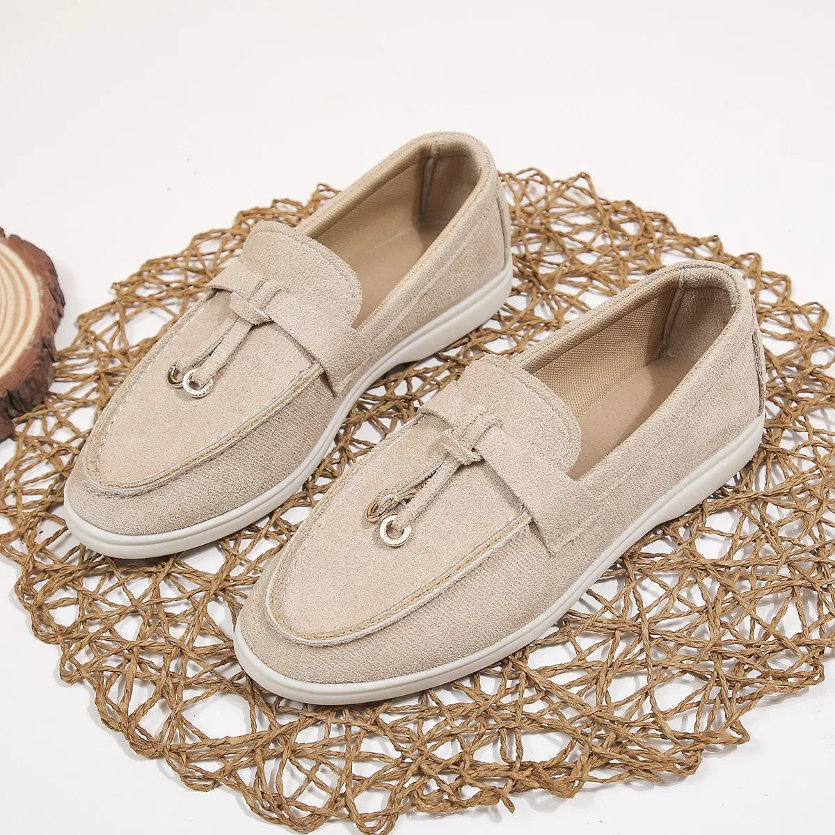 Pair of beige loafers on a textured woven mat