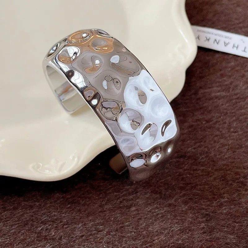 Silver and gold ring on a textured surface