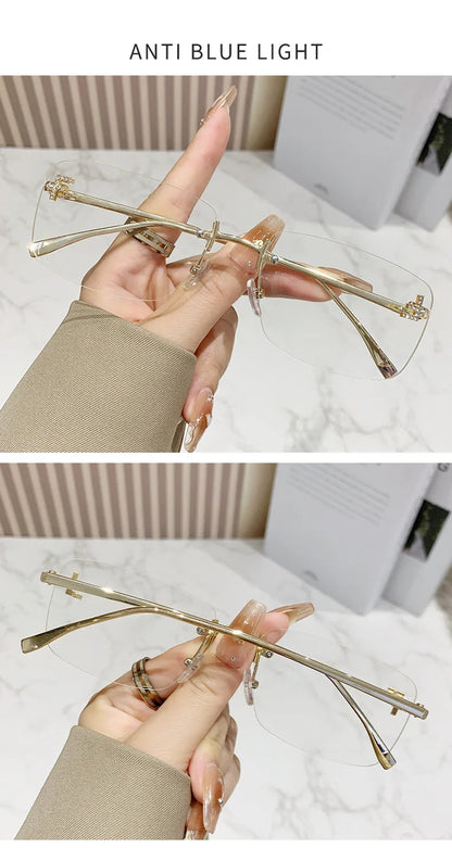 Gold-framed glasses held by a hand with a blurred background