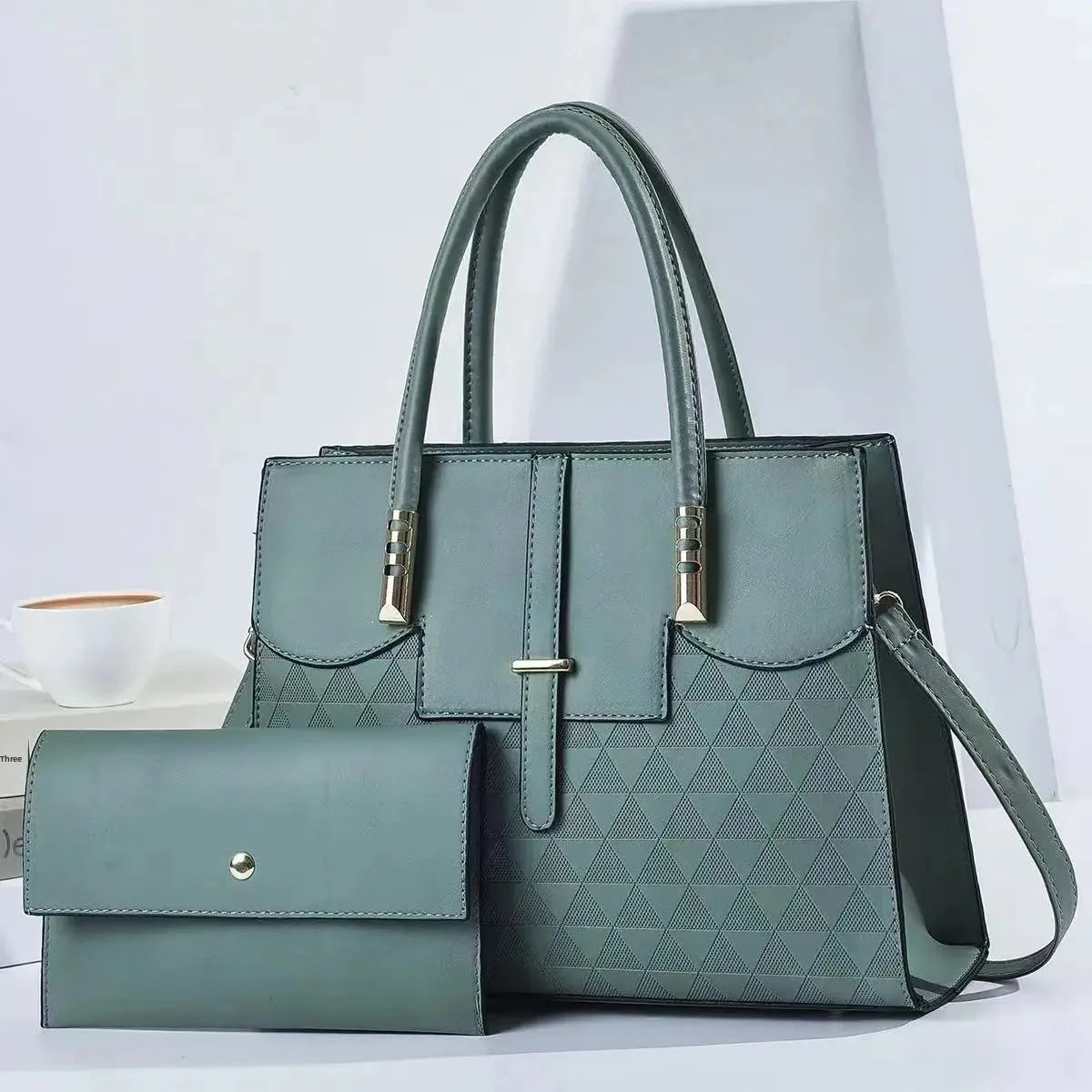 Green handbag with matching wallet on a light gray background