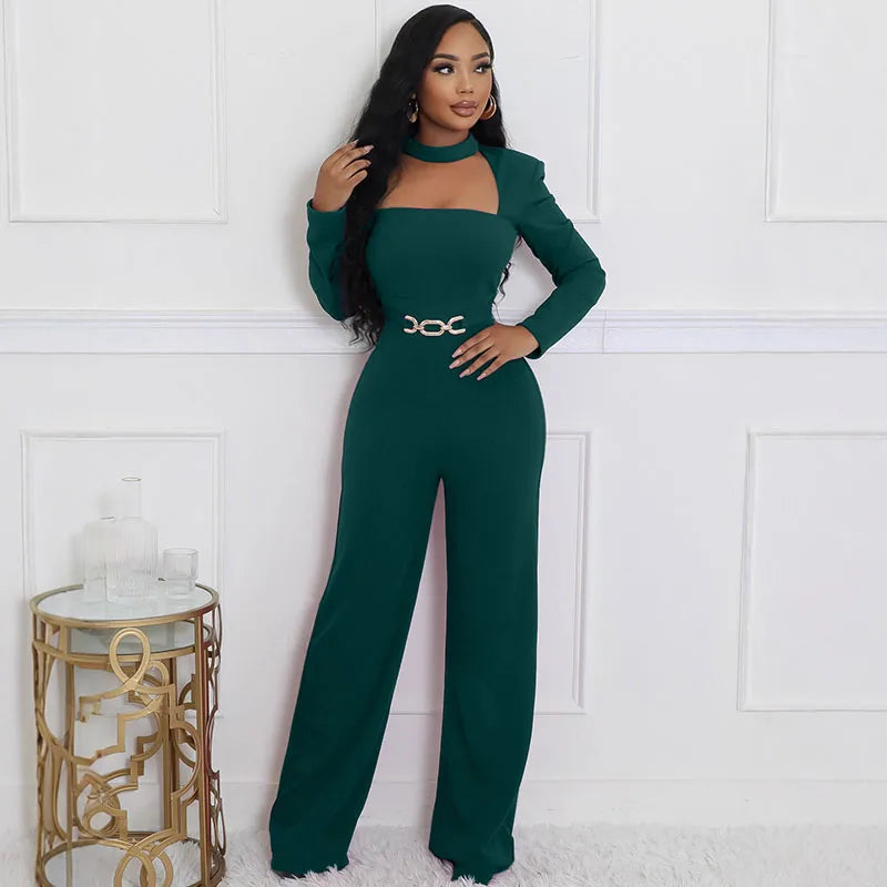 Woman wearing a green jumpsuit with a white wall background