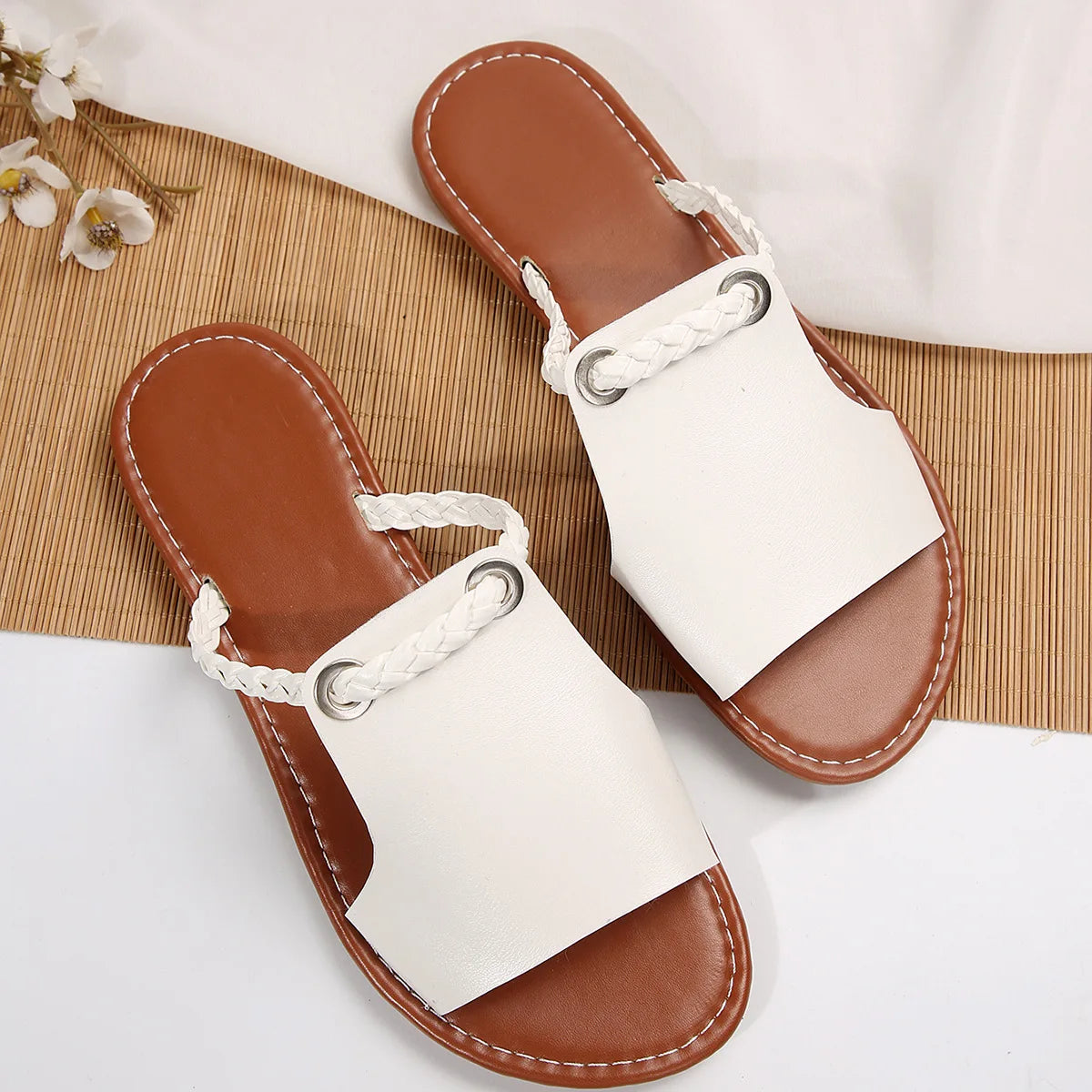 Pair of brown and white sandals on a light background
