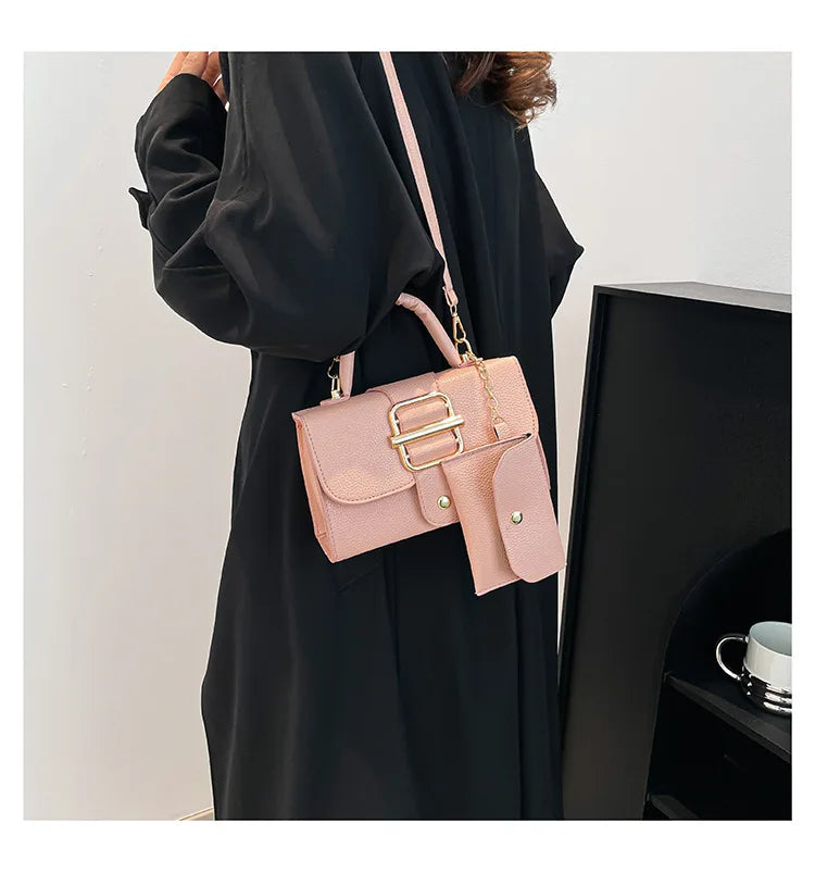 Person wearing a black coat with a pink handbag featuring gold accents.