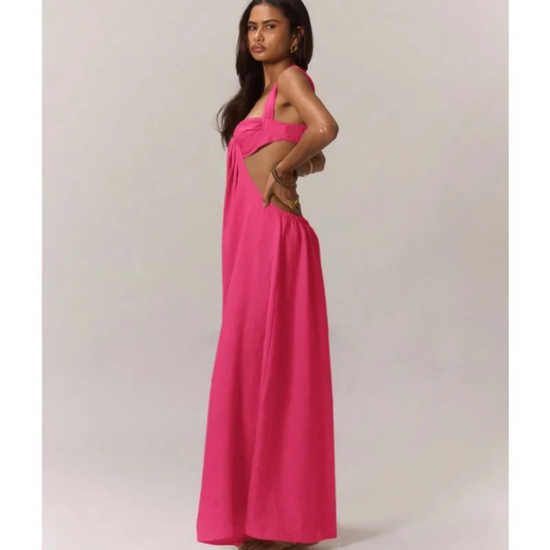 Woman wearing a bright pink dress with cut-out design on a plain background