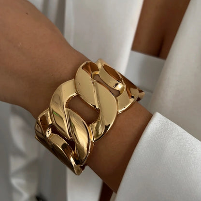 Gold chain bracelet on a wrist with a blurred background