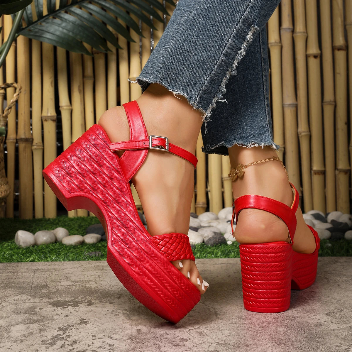 Red platform sandals worn with blue jeans against a natural background