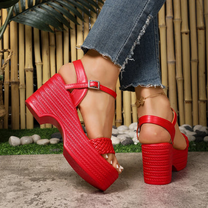 Red platform sandals worn with blue jeans against a natural background