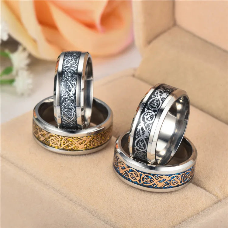 Two silver rings with intricate designs on a beige surface