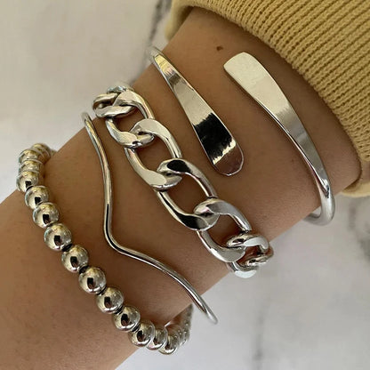 Silver bracelets on a wrist against a neutral background