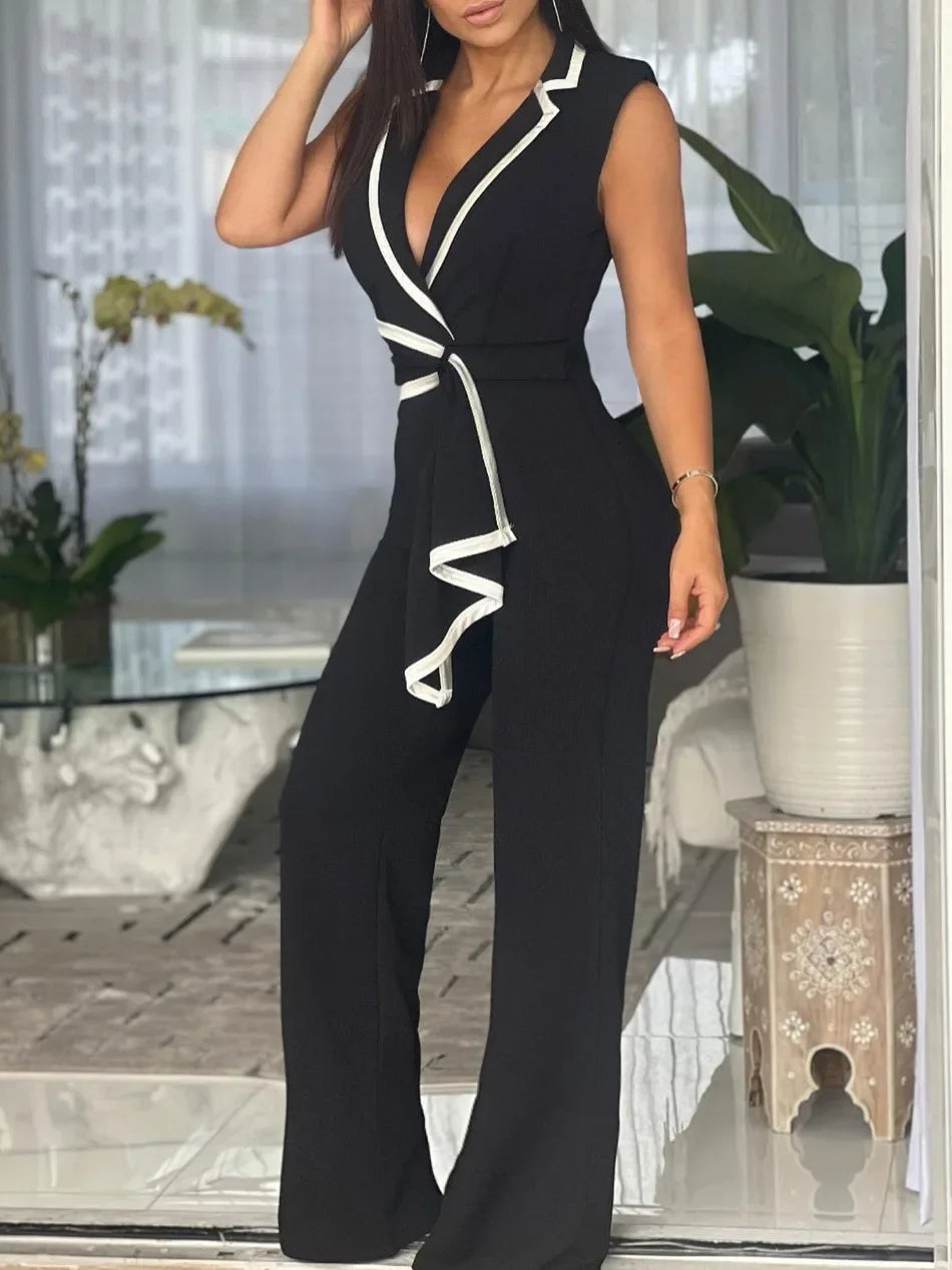 Woman wearing a black jumpsuit with white trim in an indoor setting.