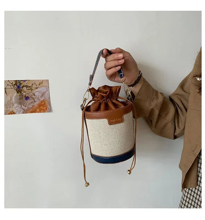 Person holding a drawstring bag with a brown and beige design against a plain background