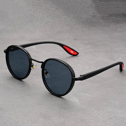 Retro round sunglasses with black frames, dark grey lenses, and black temple arms