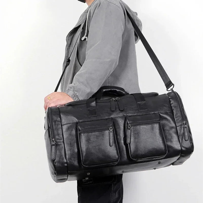 Person holding a black leather duffel bag against a white background